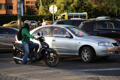 Vehículo y motocicleta en las vías.